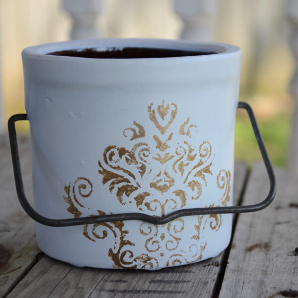 butter crock repurposed into a planter painted white with metallic decorative stencil and original metal handle