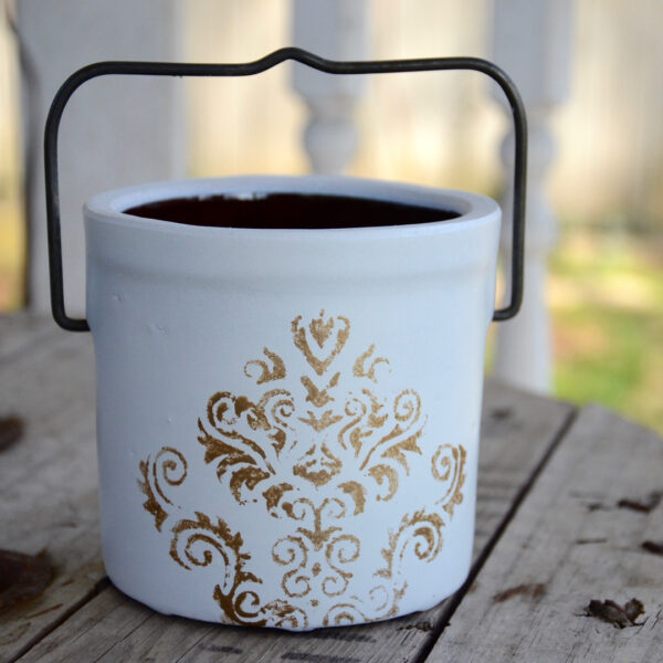 Vintage butter crock stenciled with metallic paint.