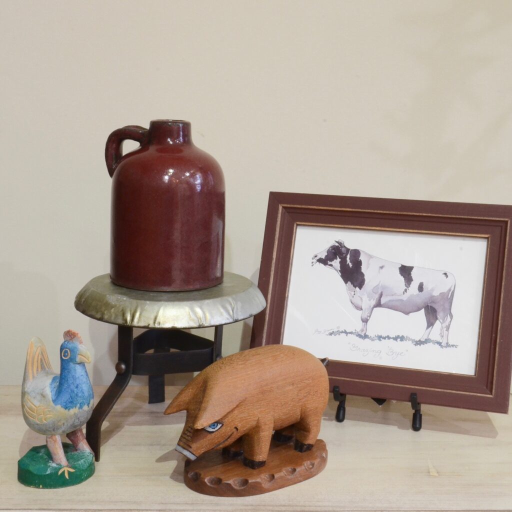 arrangement with farm animals including rooster, pig, framed cow print, an antique jug, and mini milking stool